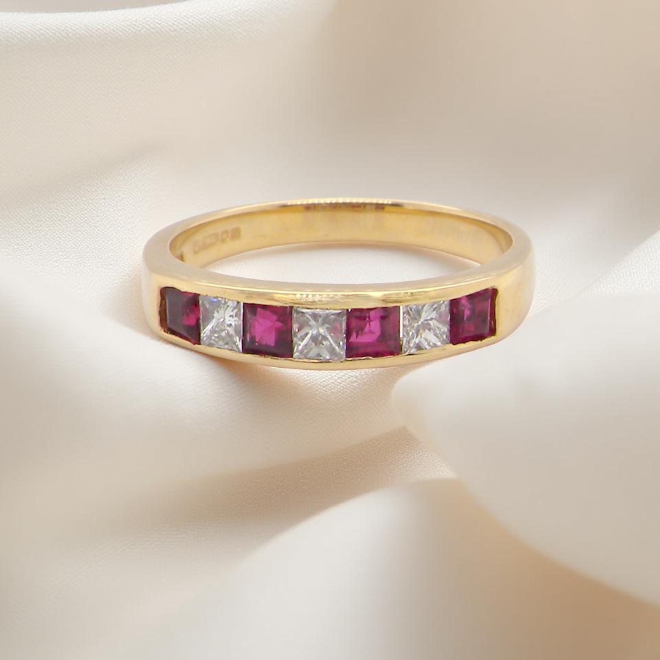 A beautiful gold half-hoop eternity ring with alternating rubies and diamonds.