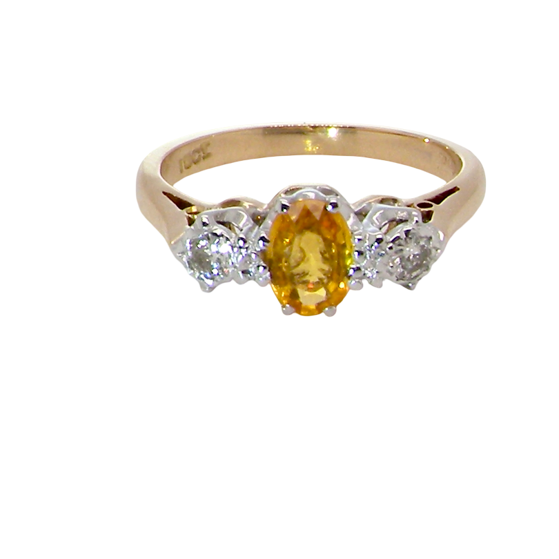 A yellow gold ring with a central oval yellow gemstone and two round clear accent stones on either side, shown on a plain white background.