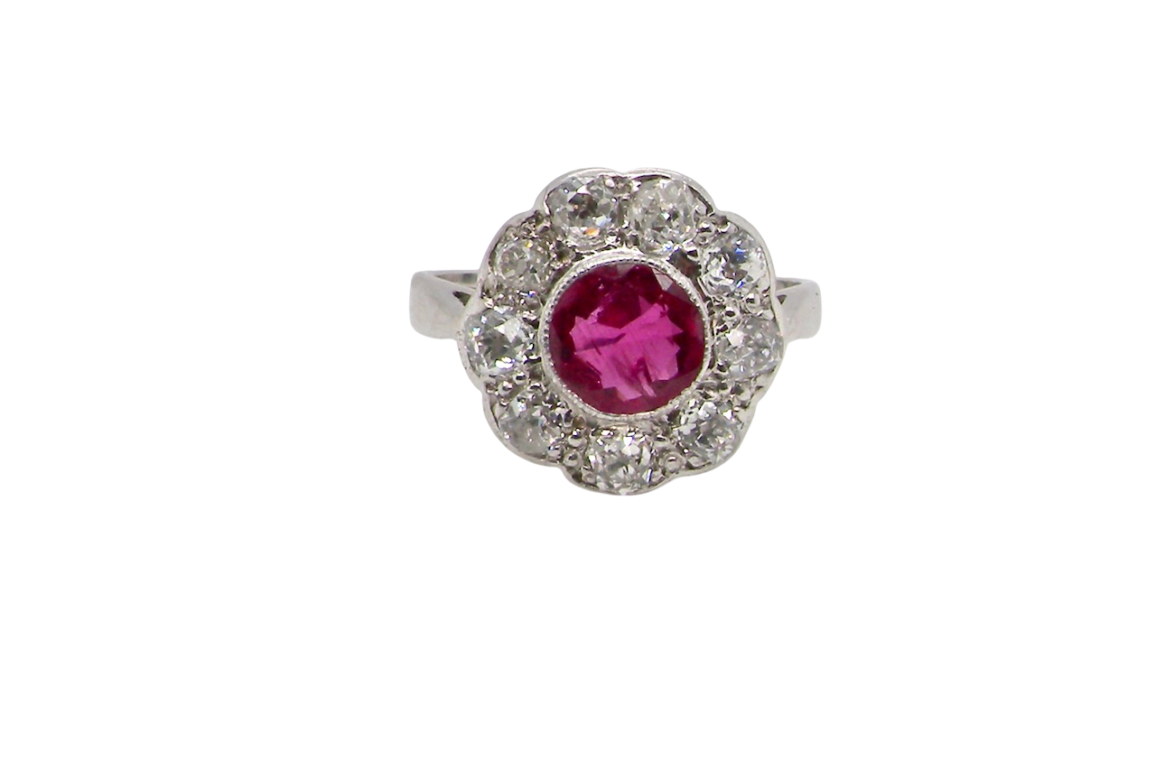 Ring with a pink gemstone and diamond-studded halo on a white background