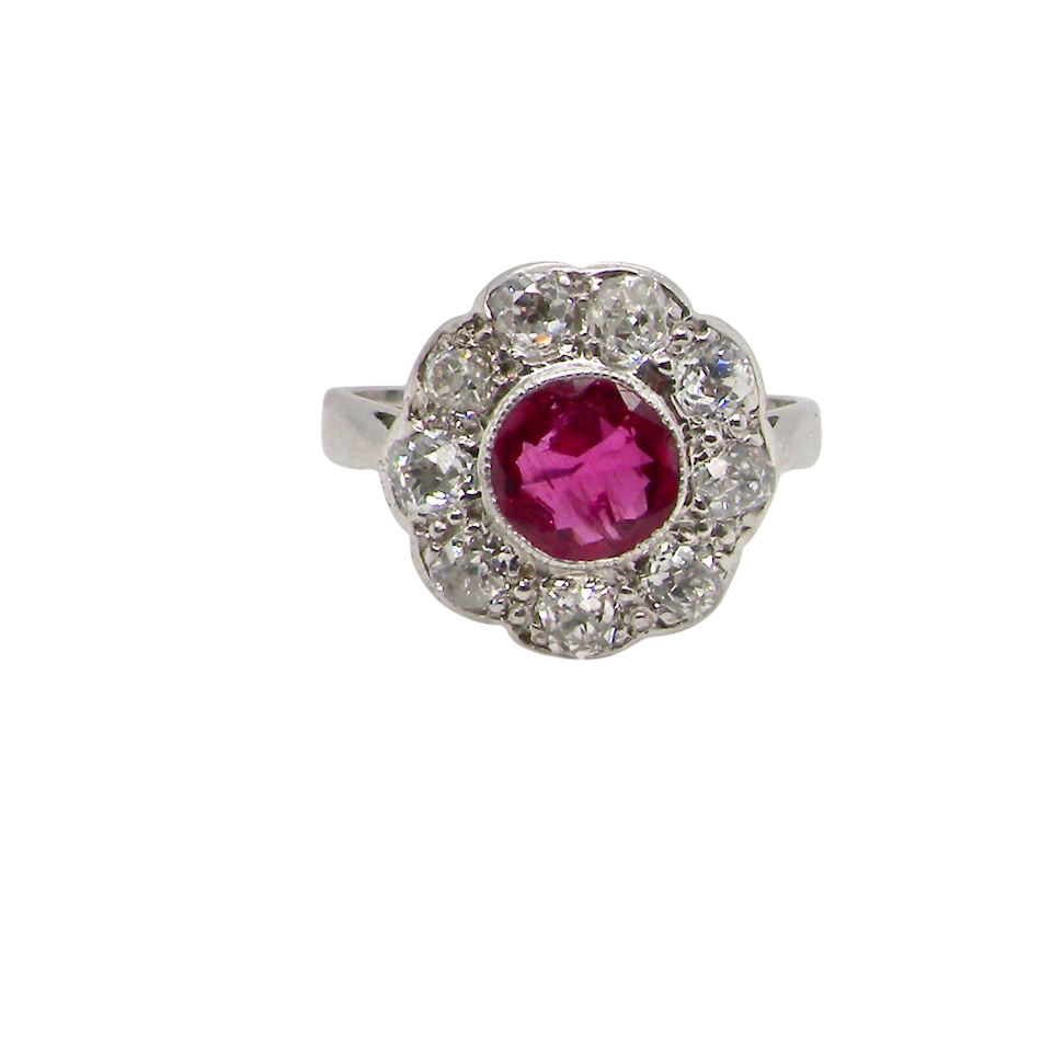 Ring with a pink gemstone and diamond-studded halo on a white background