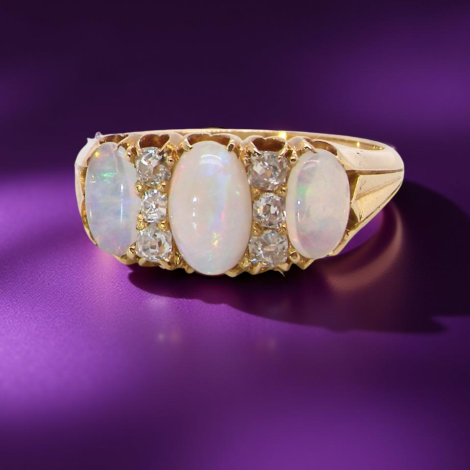 A beautiful Victorian dress ring, set with three matched oval opals,