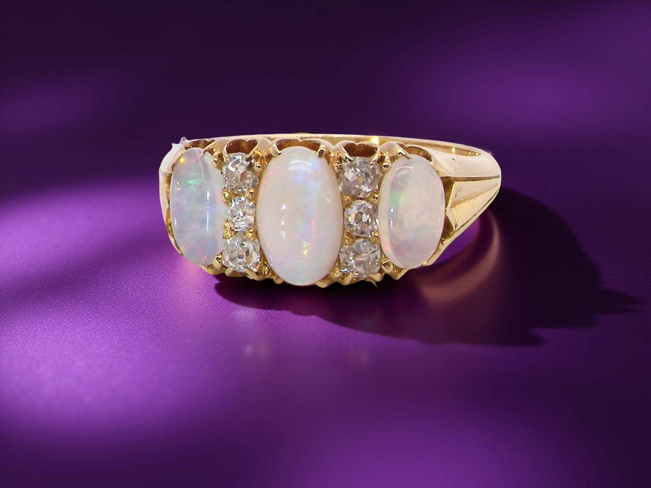 A beautiful Victorian dress ring, set with three matched oval opals,