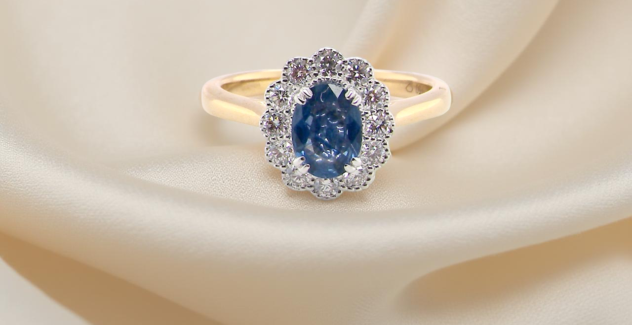 A ring featuring an oval-cut mid to dark blue sapphire measuring 7 × 5 mm (approximately ¾ carat).