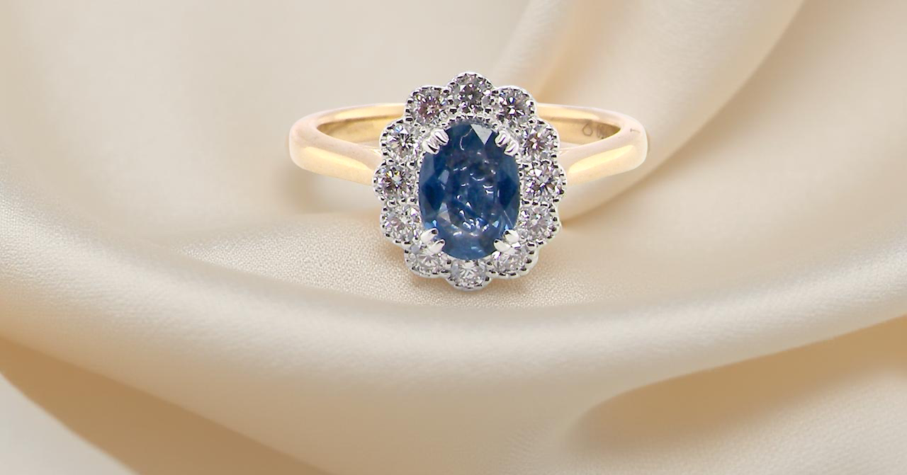A ring featuring an oval-cut mid to dark blue sapphire measuring 7 × 5 mm (approximately ¾ carat).