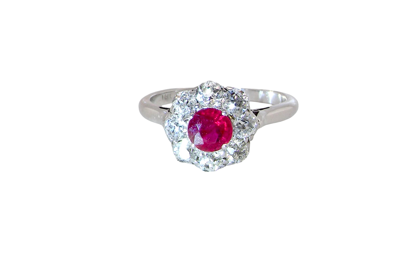 A beautiful cluster ring set with a raspberry-red ruby centre stone measuring 5mm in diameter,