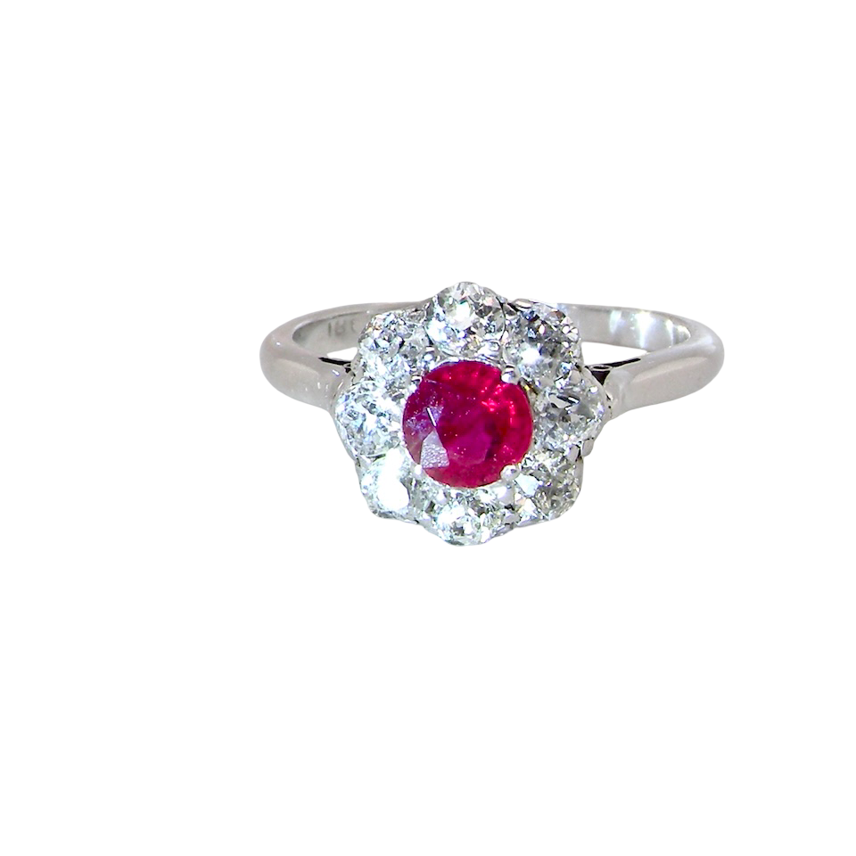 A beautiful cluster ring set with a raspberry-red ruby centre stone measuring 5mm in diameter,