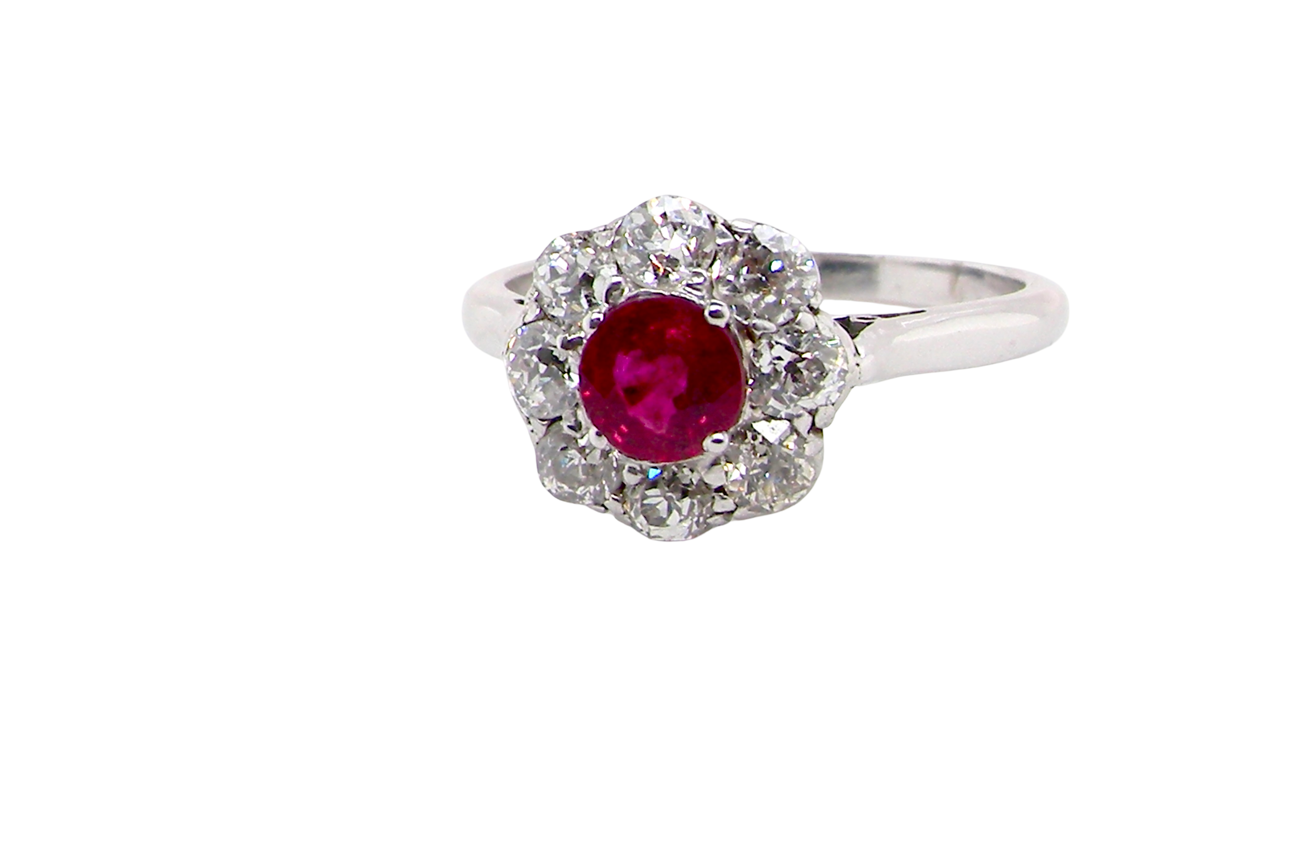 A beautiful cluster ring set with a raspberry-red ruby centre stone measuring 5mm in diameter, estimated at approximately 0.50 carats.