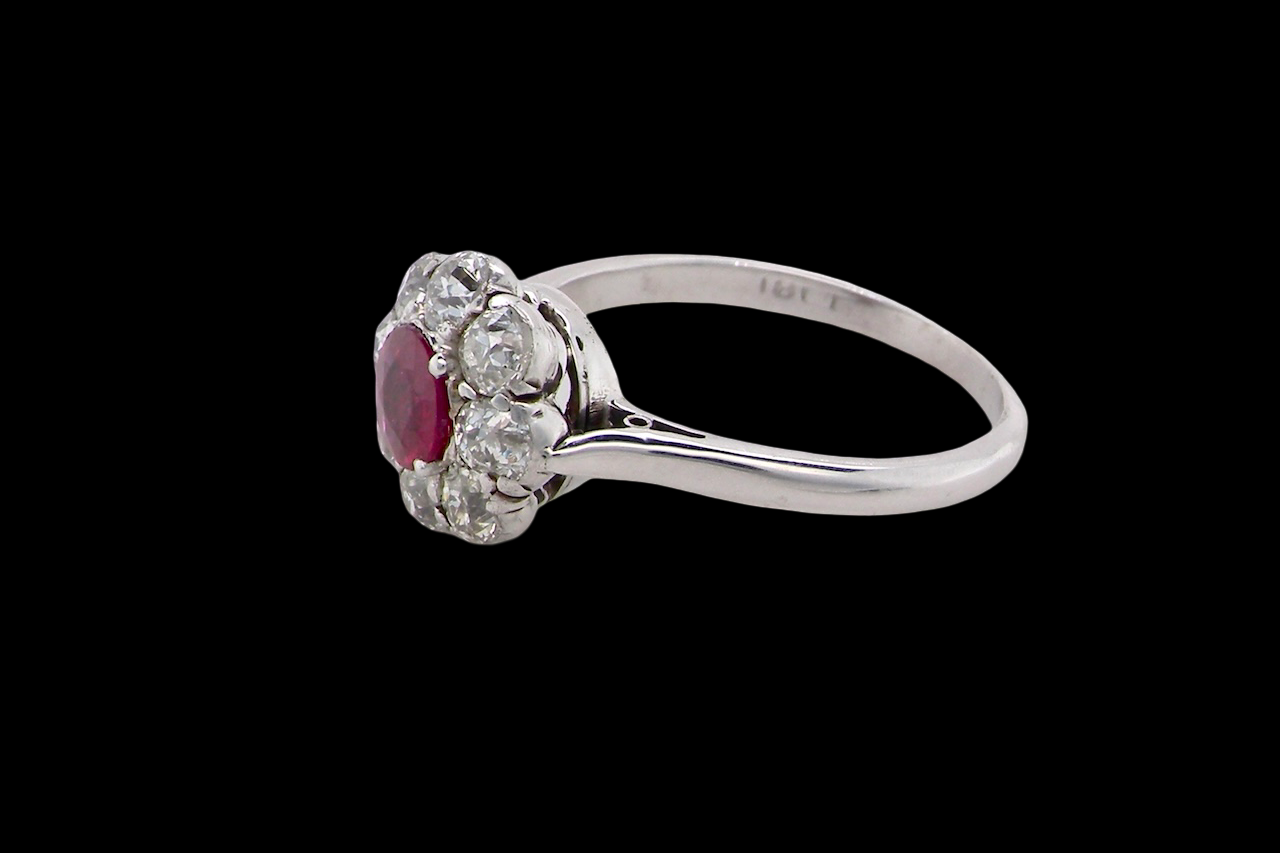 A beautiful cluster ring set with a raspberry-red ruby centre stone measuring 5mm in diameter, estimated at approximately 0.50 carats. side view