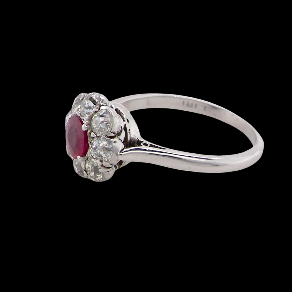 A beautiful cluster ring set with a raspberry-red ruby centre stone measuring 5mm in diameter, estimated at approximately 0.50 carats. side view