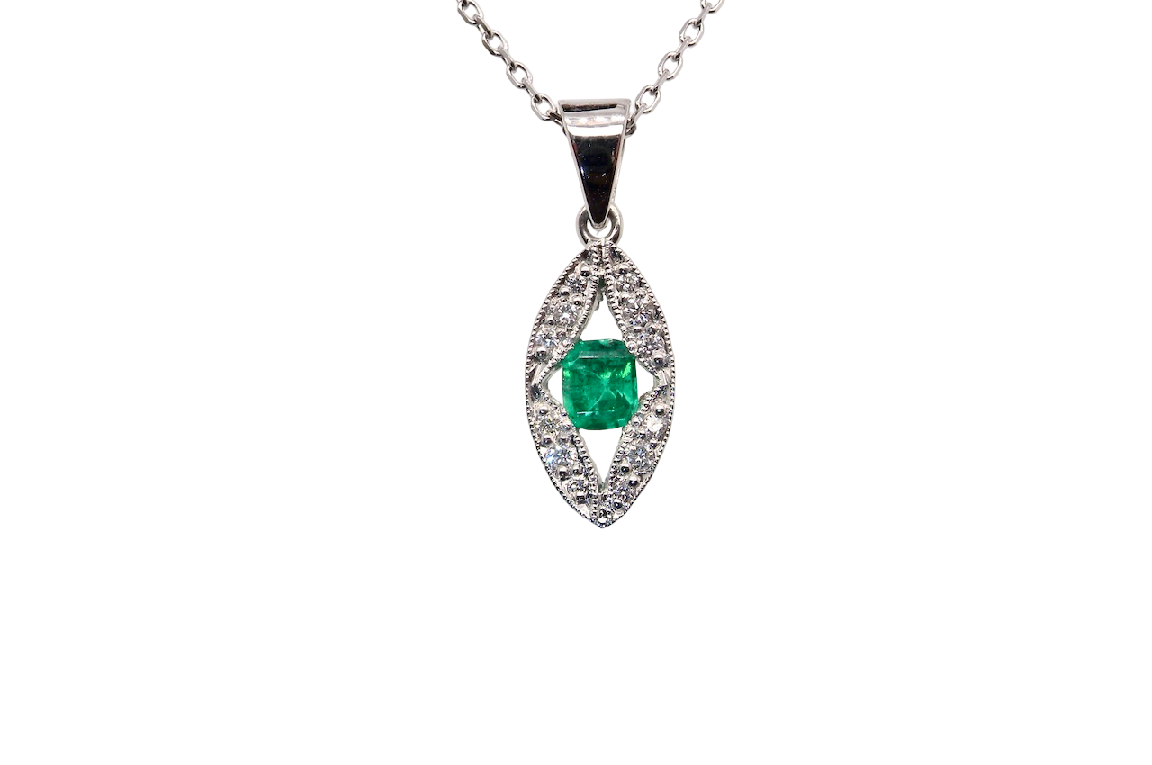 A beautiful modern 18ct white gold pendant featuring a cushion-cut emerald measuring approximately 4 x 3.5mm (estimated 0.35 carat), displaying a rich deep grass-green hue.