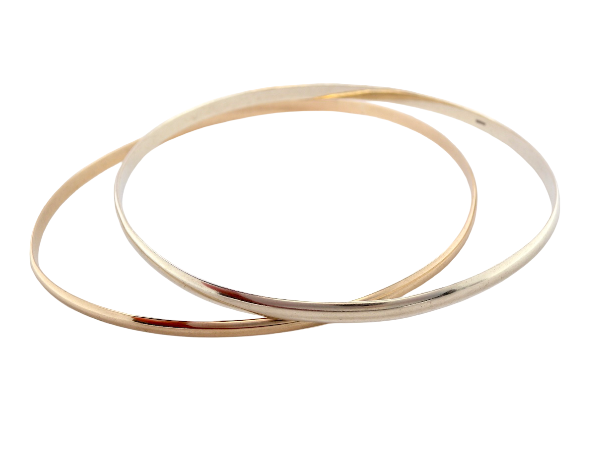 A beautiful pair of solid 9 carat gold bangles, featuring one in white gold and one in yellow gold. These classic circular bangles are timeless, elegant pieces that can be worn individually