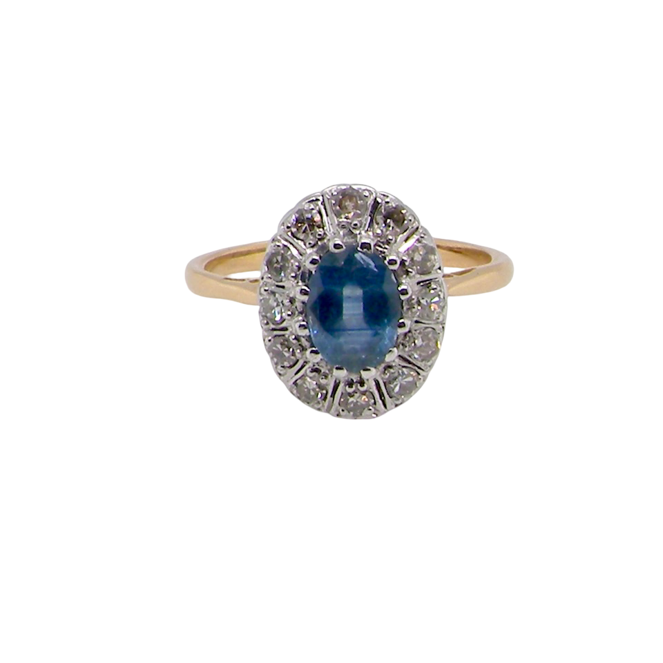 A beautiful vintage cluster ring featuring an oval mid-blue sapphire