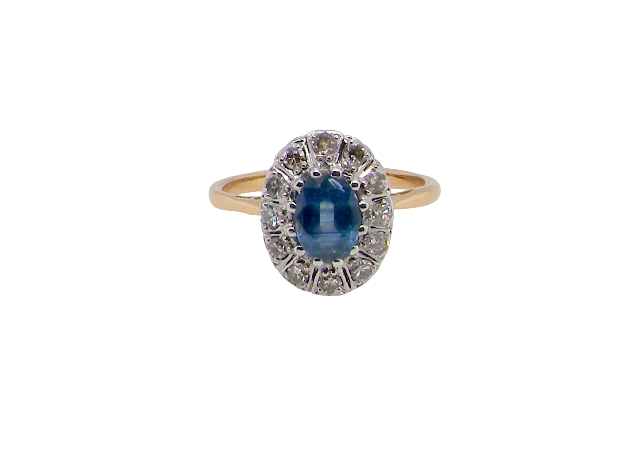 A beautiful vintage cluster ring featuring an oval mid-blue sapphire