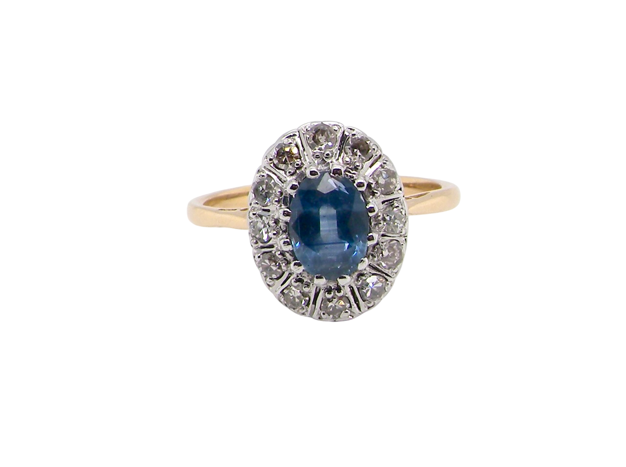 A pretty vintage cluster ring featuring an oval mid-blue sapphire