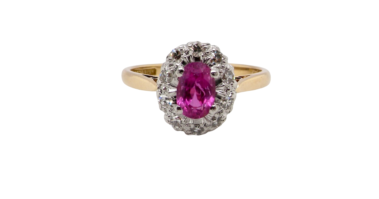 A beautiful vintage cluster ring showcasing a vivid pink sapphire centre stone, measuring approximately 6.6 × 4.3 mm(estimated 0.65 carats).