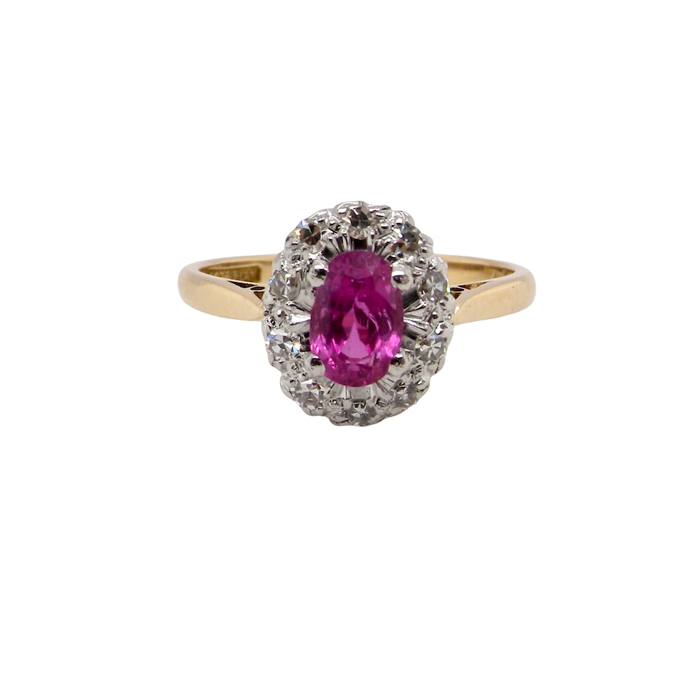A beautiful vintage cluster ring showcasing a vivid pink sapphire centre stone, measuring approximately 6.6 × 4.3 mm(estimated 0.65 carats).