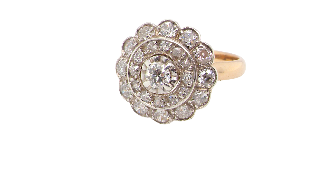 A beautiful vintage diamond cluster ring. Know as a target cluster, the diamonds are old brilliant cut. Centre diamond (0.20 carats) . 