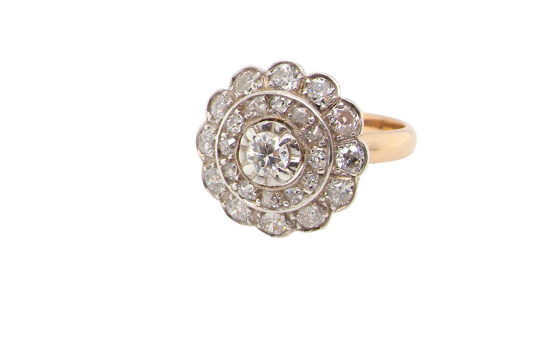 A beautiful vintage diamond cluster ring. Know as a target cluster, the diamonds are old brilliant cut. Centre diamond (0.20 carats) . 