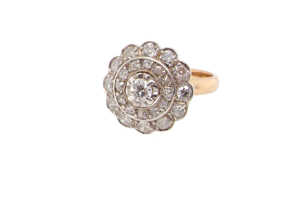 A beautiful vintage diamond cluster ring. Know as a target cluster, the diamonds are old brilliant cut. Centre diamond (0.20 carats) . 