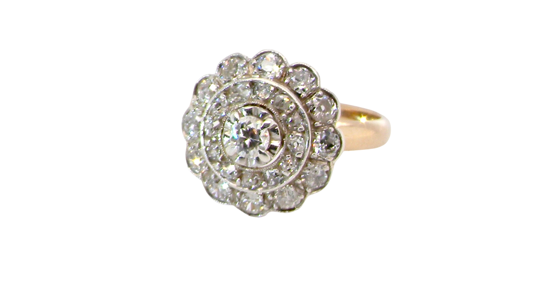 A beautiful vintage diamond cluster ring. Know as a target cluster, the diamonds are old brilliant cut. Centre diamond 3.8mm . 