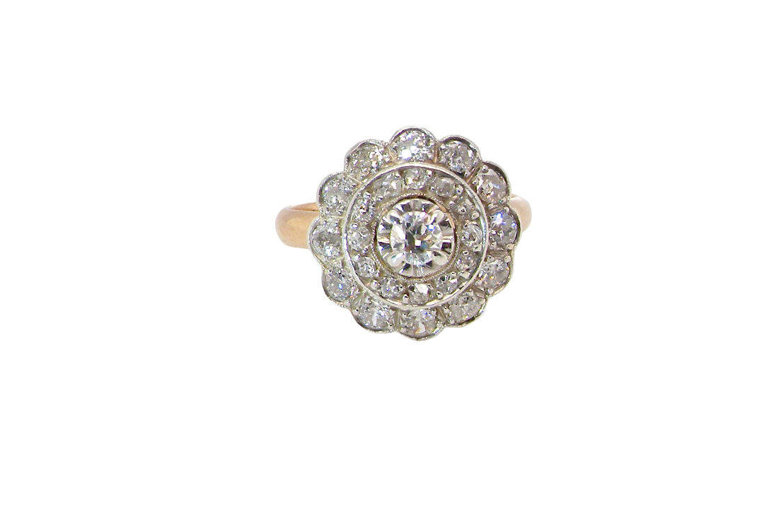 A beautiful vintage diamond cluster ring. Know as a target cluster, the diamonds are old brilliant cut. Centre diamond 3.8mm (0.20 carats) . 