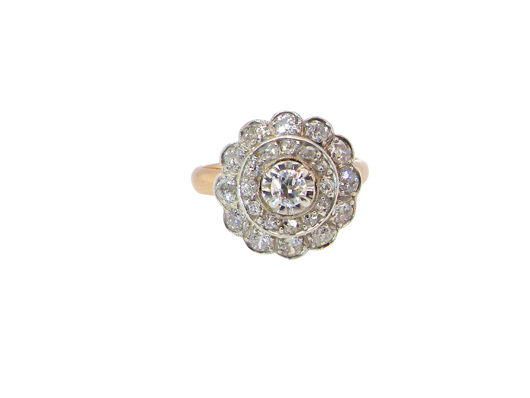 A beautiful vintage diamond cluster ring. Know as a target cluster, the diamonds are old brilliant cut. Centre diamond 3.8mm (0.20 carats) . 
