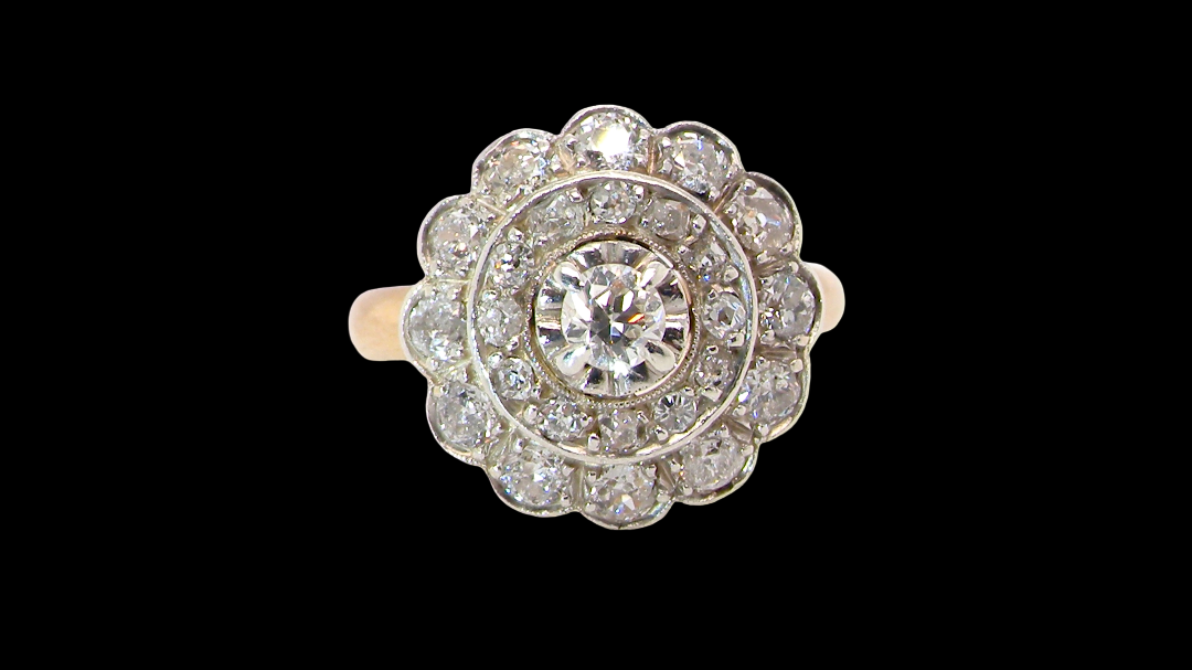 A beautiful vintage diamond cluster ring. Know as a target cluster, the diamonds are old brilliant cut. Centre diamond 3.8mm (0.20 carats) . vintage