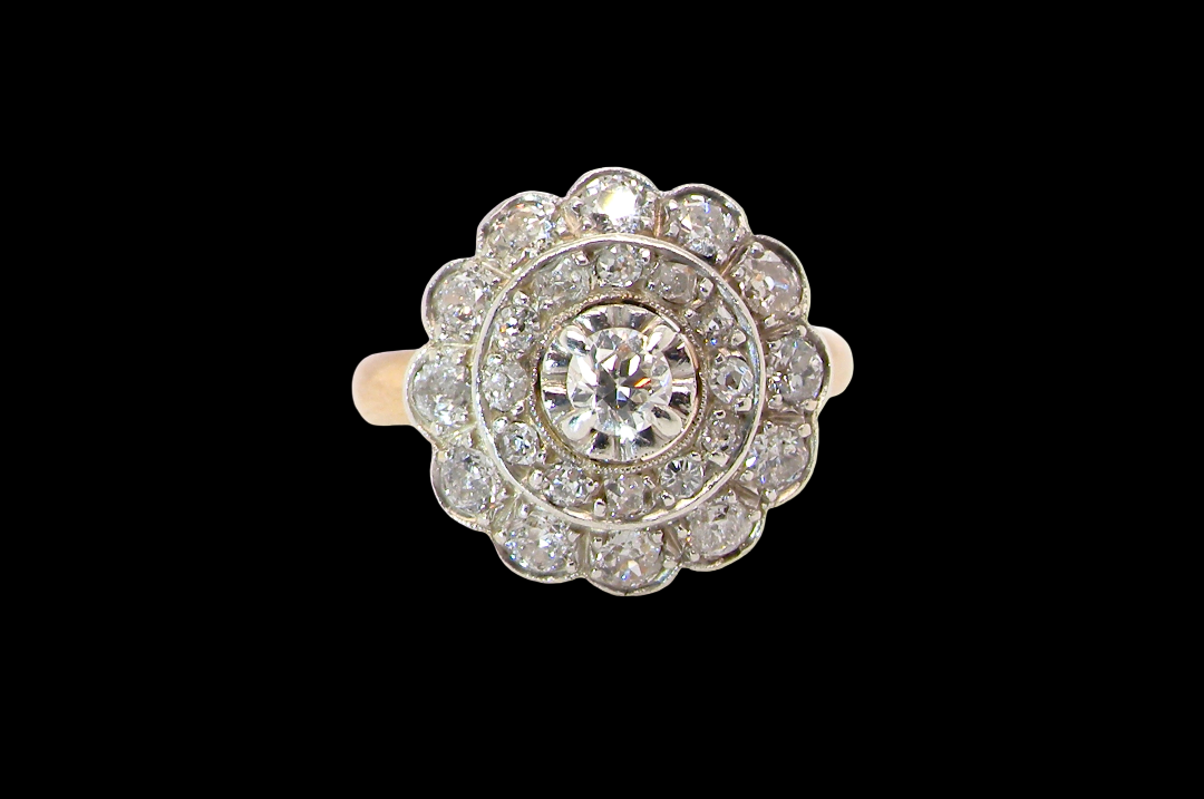 A beautiful vintage diamond cluster ring. Know as a target cluster, the diamonds are old brilliant cut. Centre diamond 3.8mm (0.20 carats) . vintage