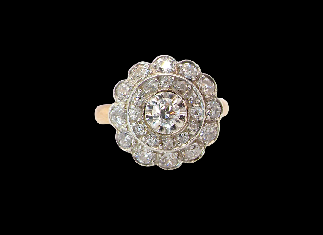 A beautiful vintage diamond cluster ring. Know as a target cluster, the diamonds are old brilliant cut. Centre diamond 3.8mm (0.20 carats) . vintage