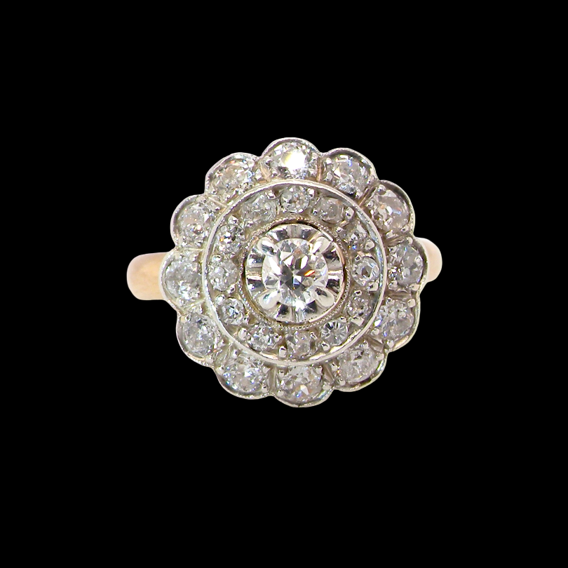 A beautiful vintage diamond cluster ring. Know as a target cluster, the diamonds are old brilliant cut. Centre diamond 3.8mm (0.20 carats) . vintage