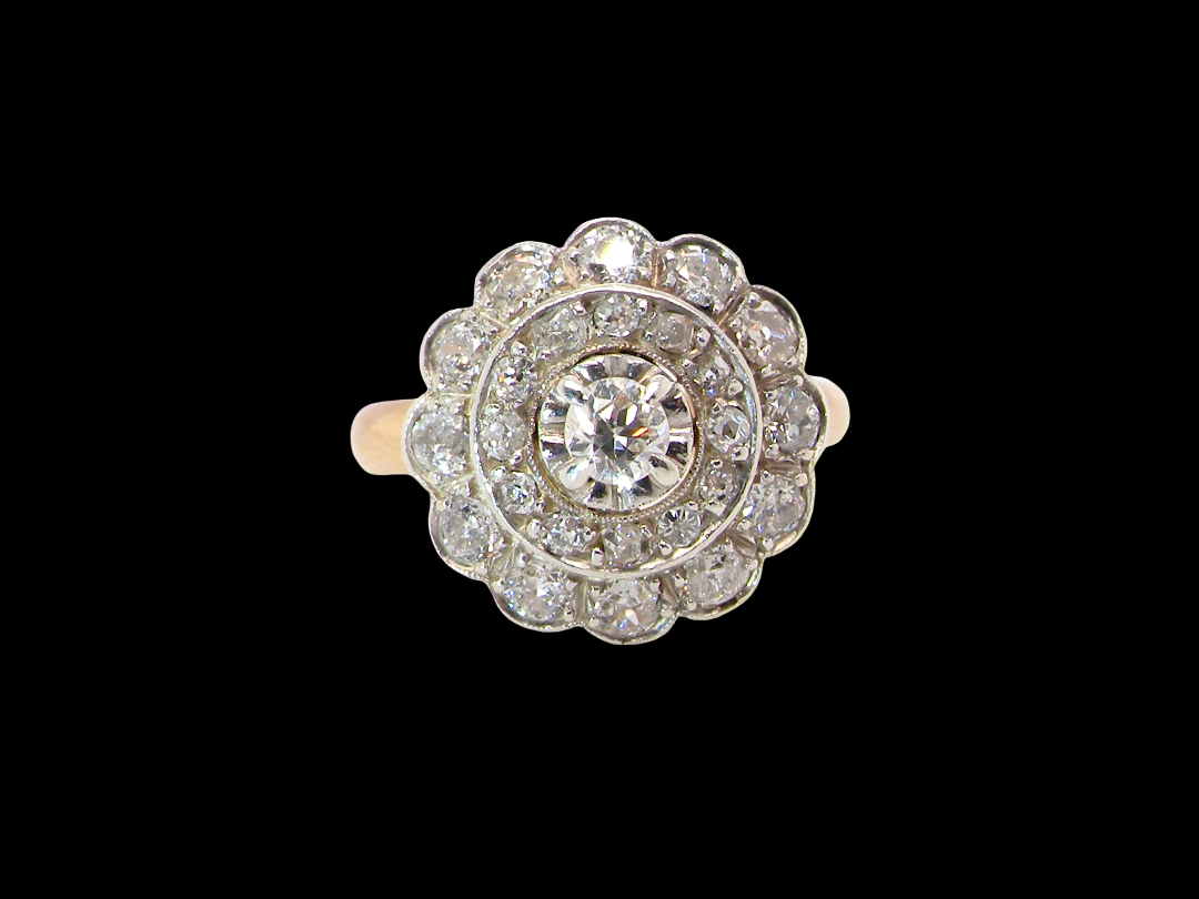 A beautiful vintage diamond cluster ring. Know as a target cluster, the diamonds are old brilliant cut. Centre diamond 3.8mm (0.20 carats) . vintage