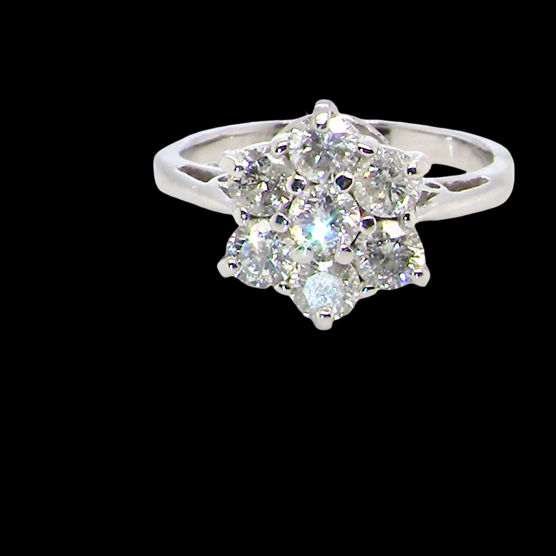 A beautiful vintage diamond cluster ring, elegantly set with seven brilliant-cut white diamonds in a floral cluster design.
