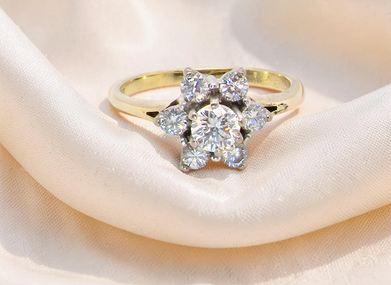 A beautifully crafted vintage diamond cluster ring, dating to the 1960s, featuring a classic floral-inspired design