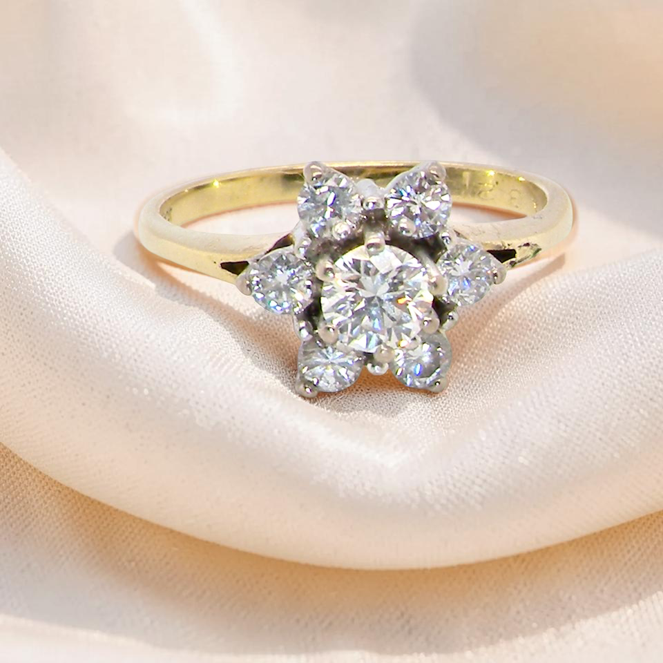 A beautifully crafted vintage diamond cluster ring, dating to the 1960s, featuring a classic floral-inspired design