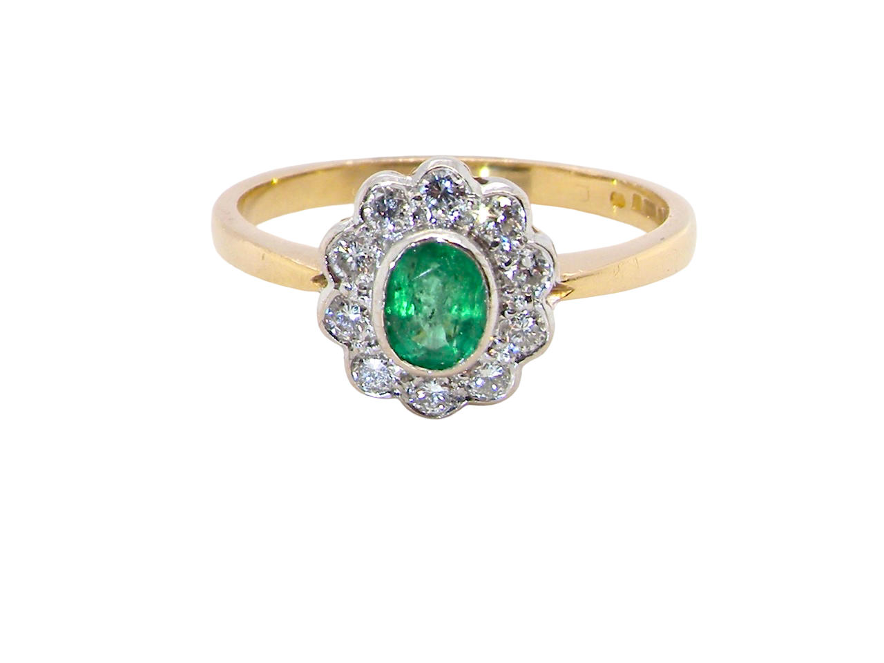 A beautifully elegant cluster ring featuring a central oval-cut emerald, (estimated 0.40 carats).