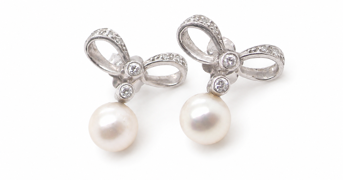 A bow design that has small diamonds to each side and the centre of the bow (approx. 0.10 carats each).