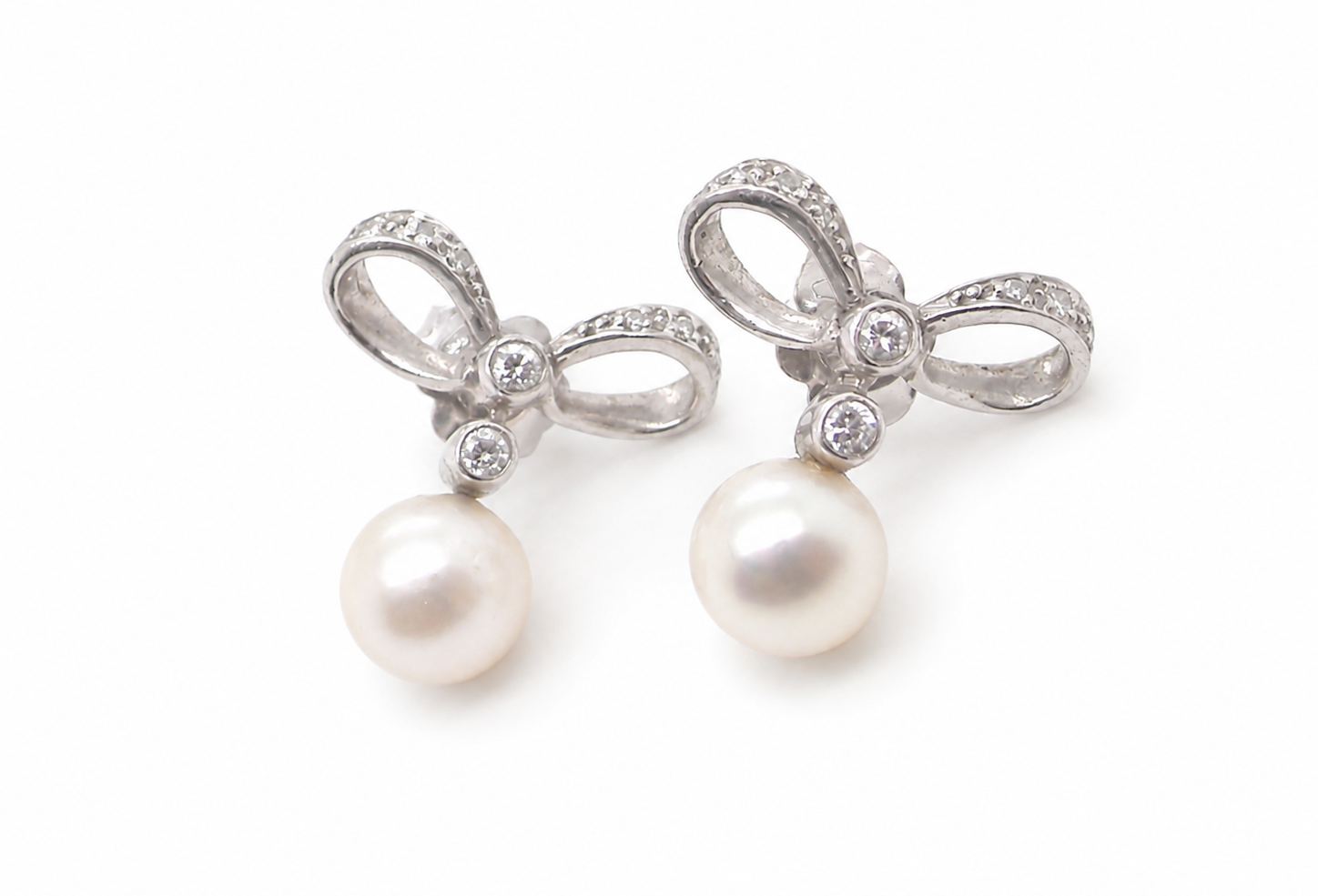 A bow design that has small diamonds to each side and the centre of the bow (approx. 0.10 carats each).