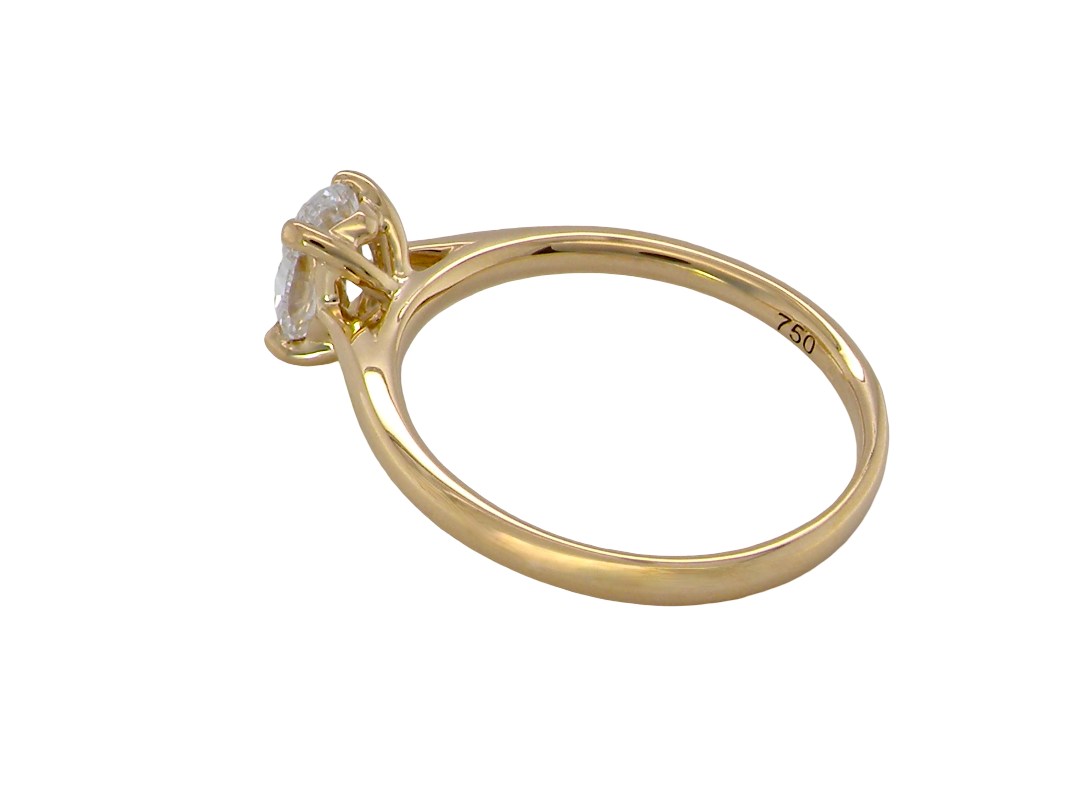 A yellow gold solitaire ring with a round-cut gemstone in a prong setting, shown from a side angle on a plain white background. The inside of the band is stamped with '750', indicating sterling gold.