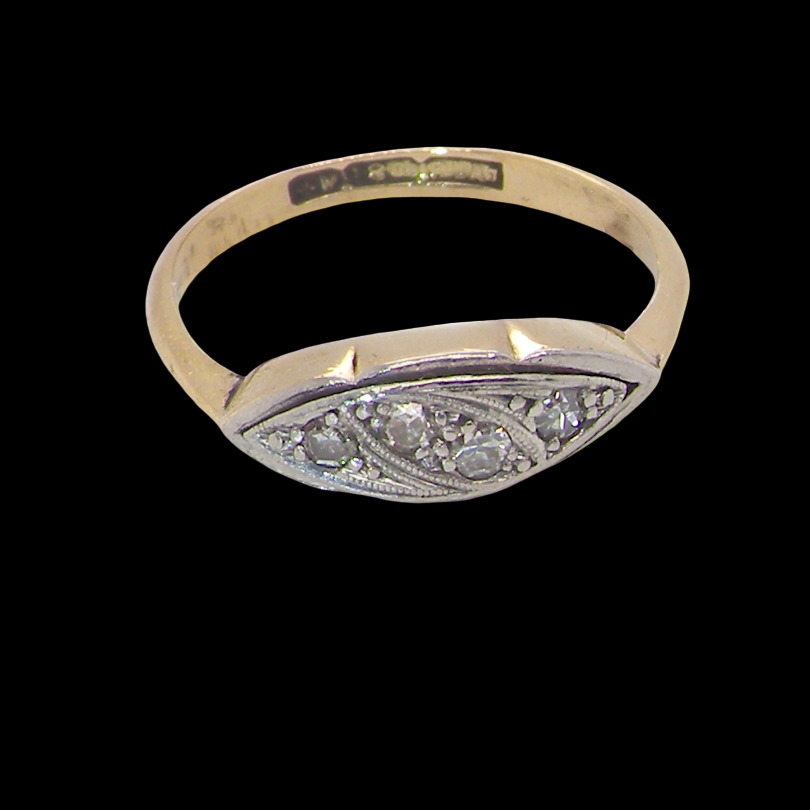 A vintage Art Deco style signet ring featuring a yellow gold band and a silver-toned oval face embellished with small round diamonds, shown against a solid black background.