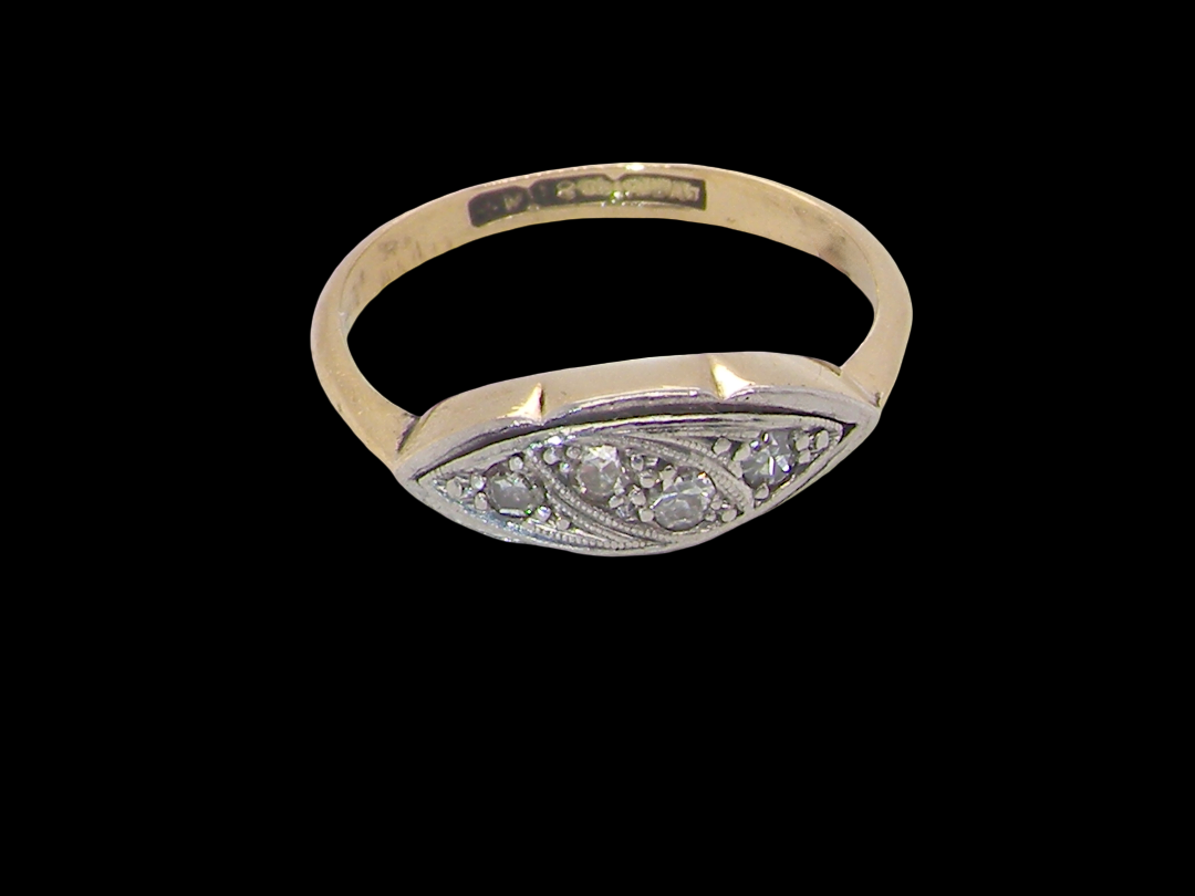 A vintage Art Deco style signet ring featuring a yellow gold band and a silver-toned oval face embellished with small round diamonds, shown against a solid black background.