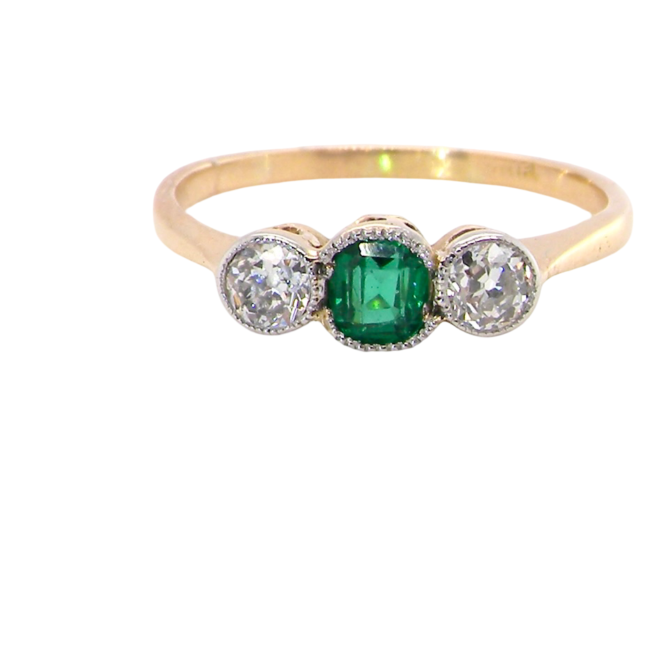 A charming ring dating from the early to mid-20th century, beautifully crafted and full of period character.
The centrepiece is a vivid bright-green, cushion-shaped emerald