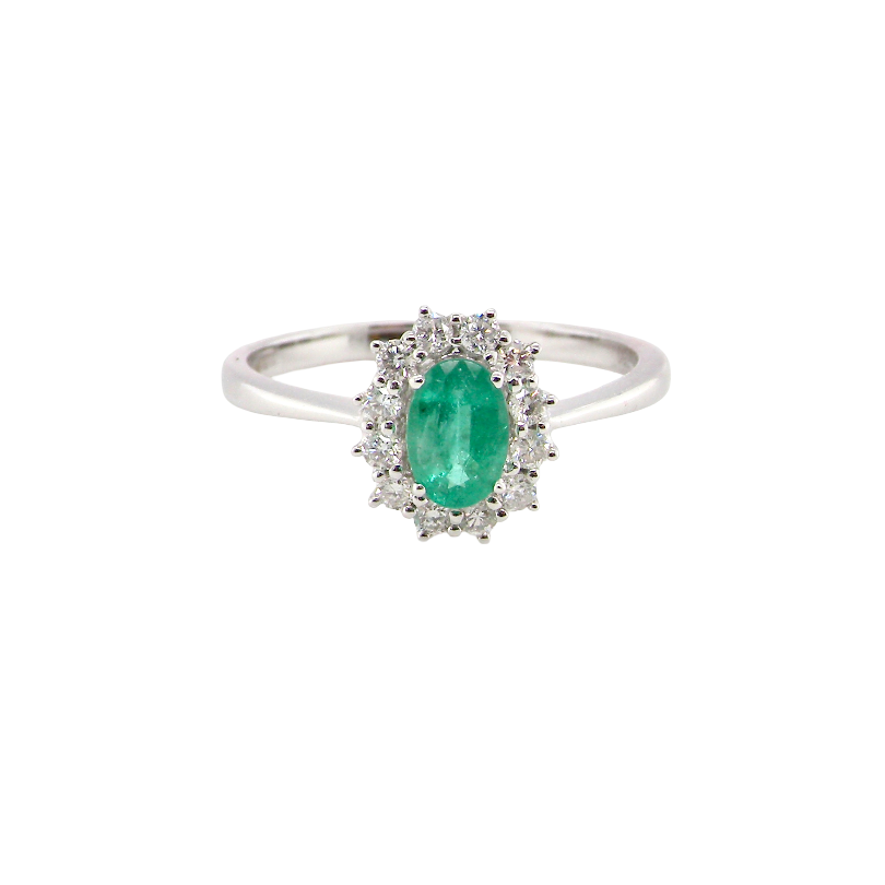 A classic cluster ring set with an oval cut emerald centre stone, measures 6x4mm, grass green colour.
Complimented by an outer halo of twelve brilliant cut white diamonds, each 1.7mm (total est at 0.25 carats)