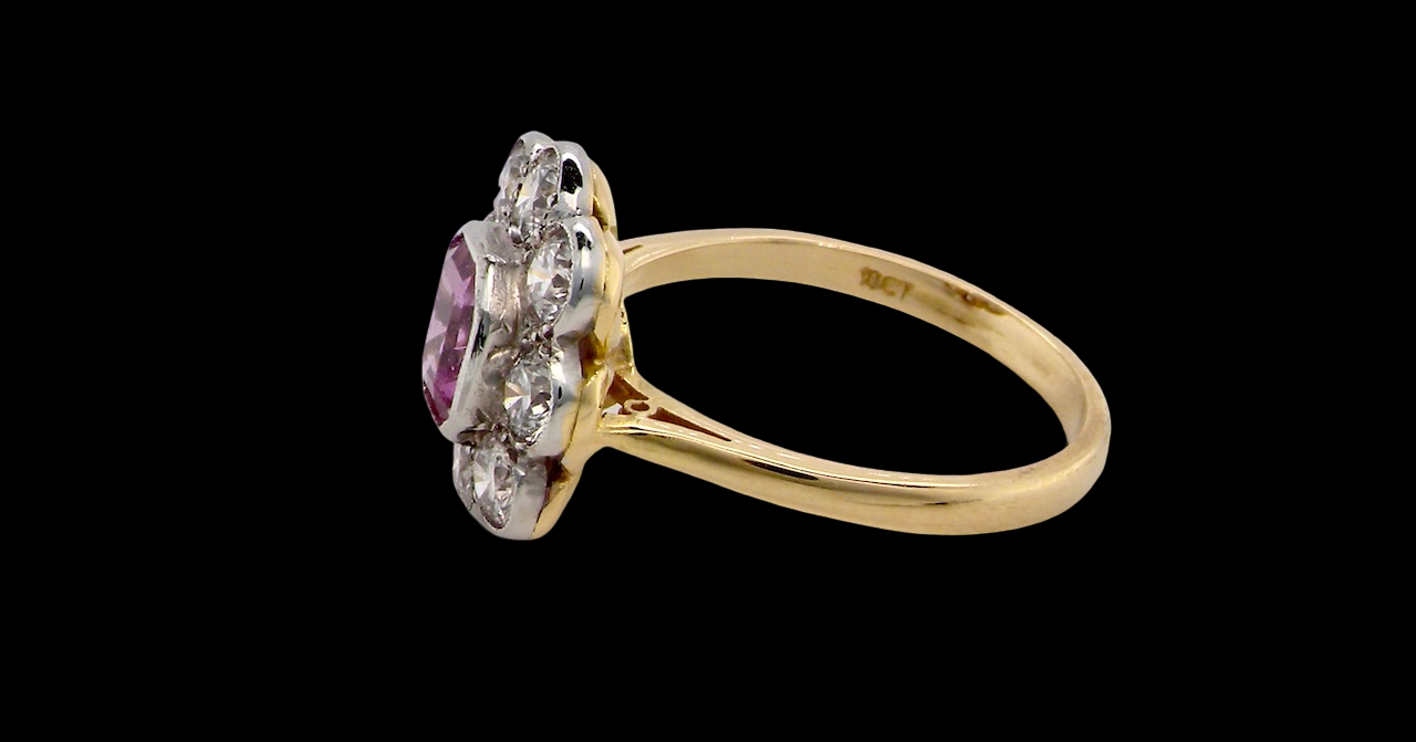 A cluster ring featuring a beautiful cushion-cut pink sapphire side view