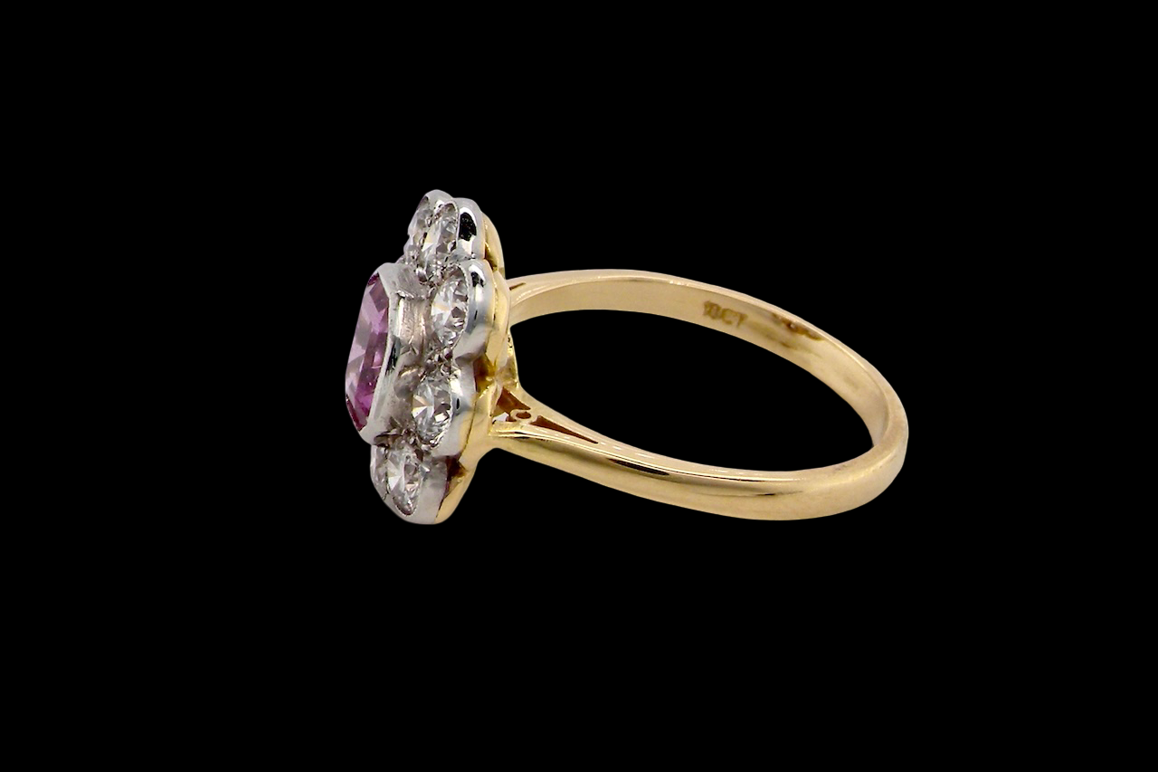 A cluster ring featuring a beautiful cushion-cut pink sapphire side view