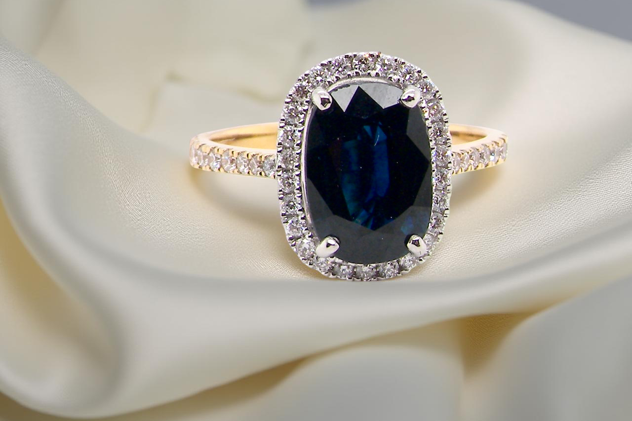 A cluster ring featuring a captivating ink-black blue sapphire, A