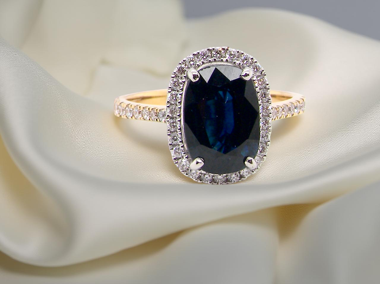 A cluster ring featuring a captivating ink-black blue sapphire, A
