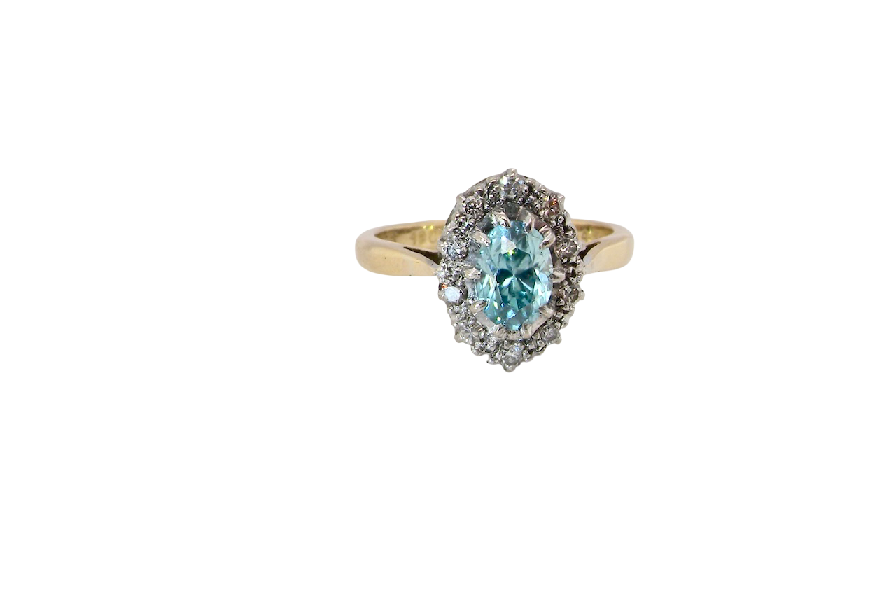 A cluster ring set with a natural blue zircon centre stone, 7.5x5mm, vibrant aquamarine colour. 