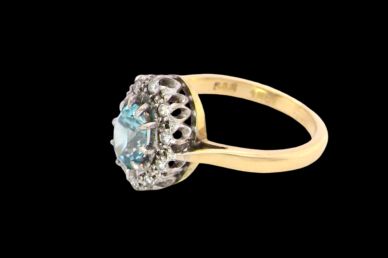 A cluster ring set with a natural blue zircon centre stone, 7.5x5mm, vibrant aquamarine colour.
side
