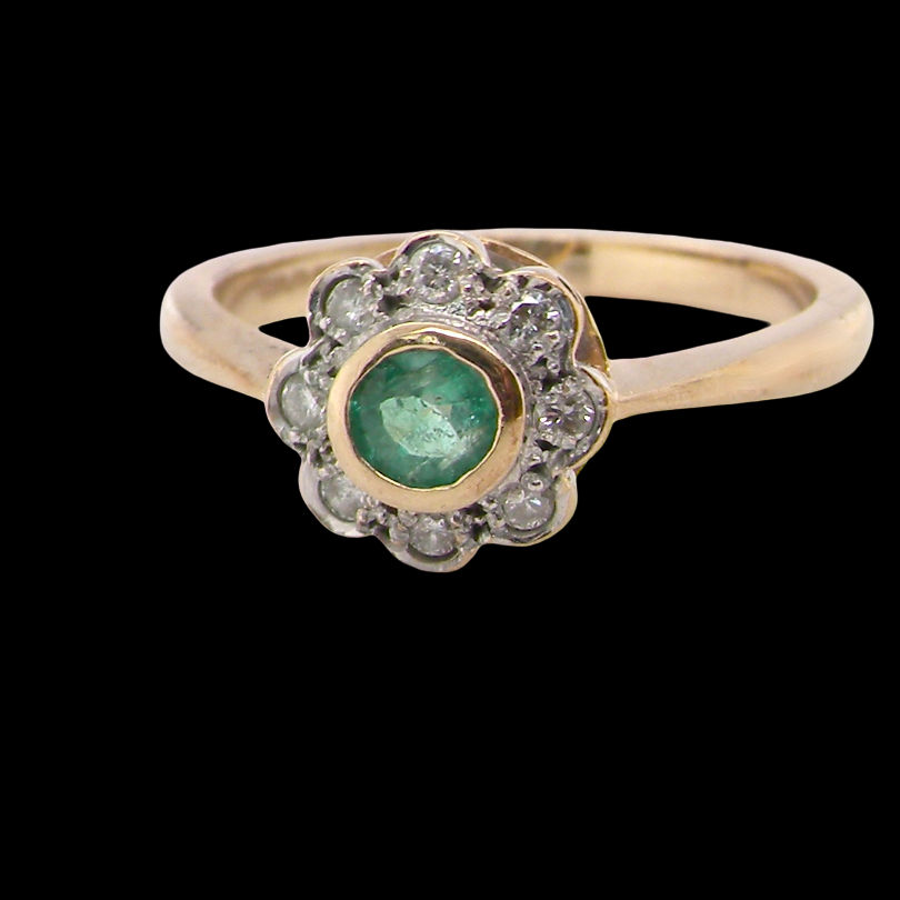 A yellow gold ring featuring a central round green emerald-cut gemstone surrounded by a halo of small clear stones, set on a solid black background.