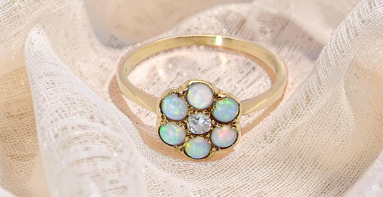 A daisy cluster dress ring. Set with a small diamond centre stone, (0.10 carats)